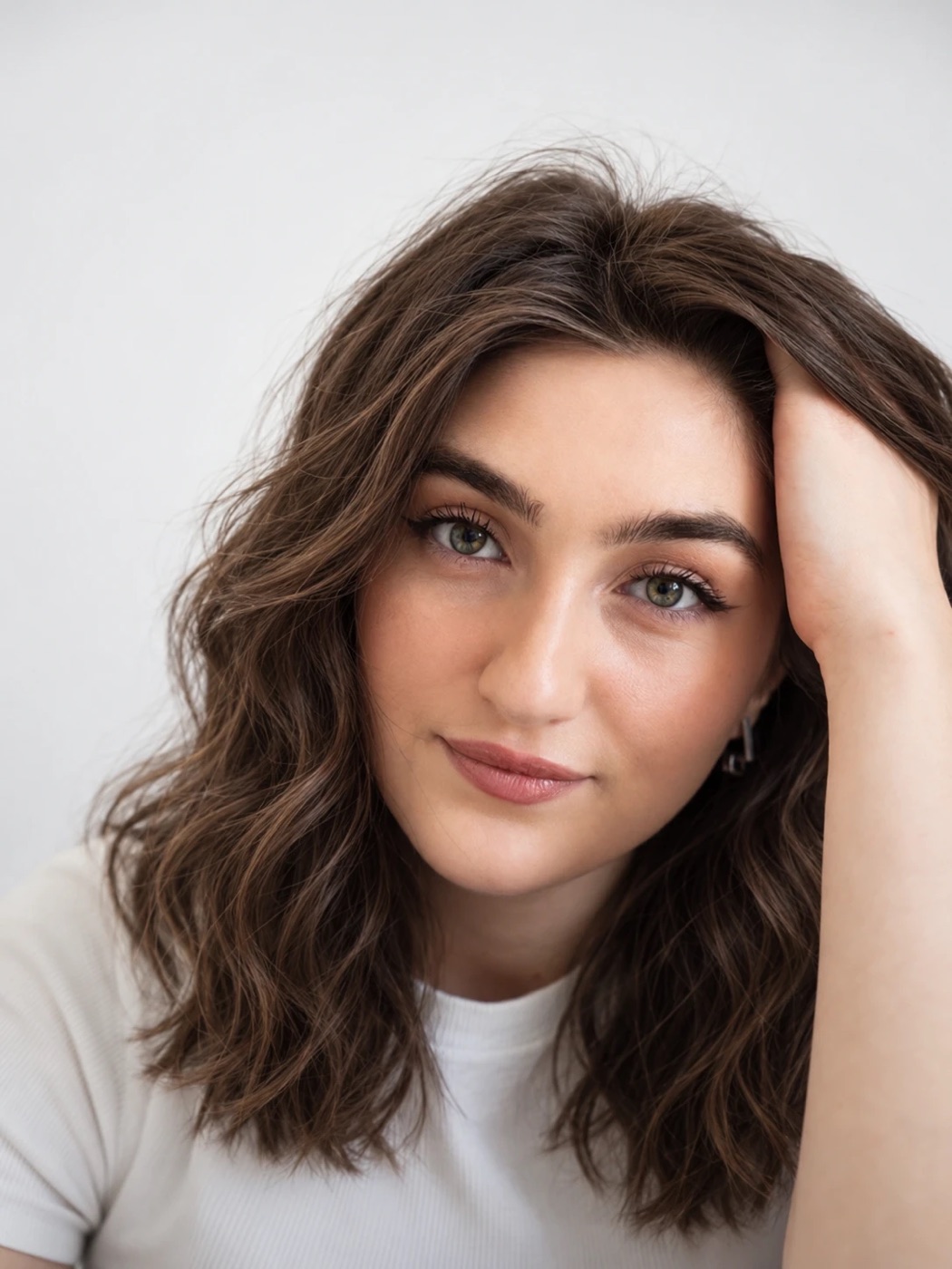 A woman facing the camera with shoulder-length brown hair in soft, tousled waves
